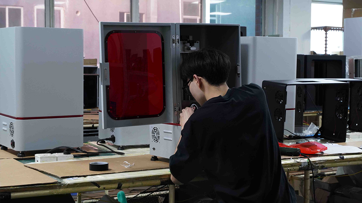 Técnico revisando piezas impresas en resina 3D después del lavado y curado UV